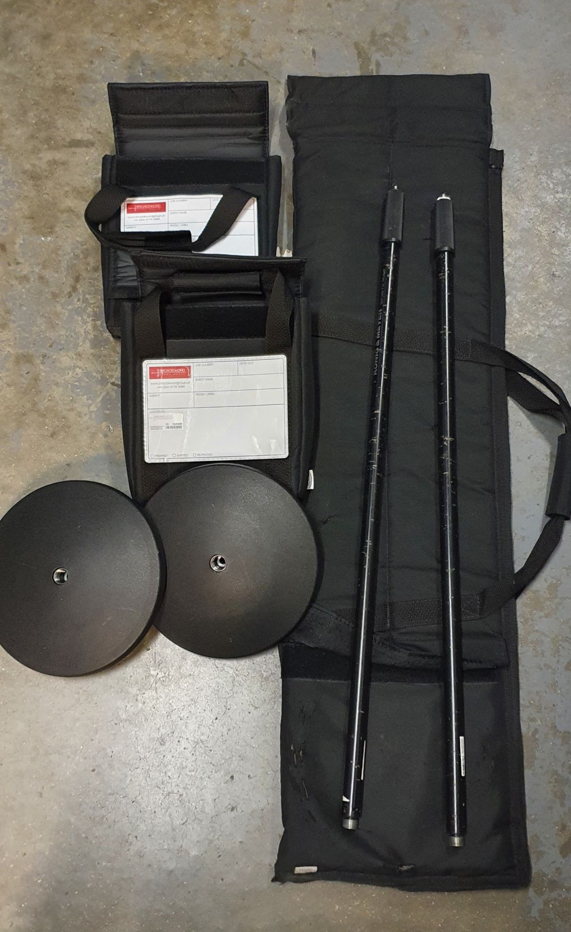A Pair of Microphone Stands with round bases and carry bags.