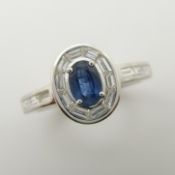 18ct white gold ring with oval-cut blue sapphire and baguette diamonds.