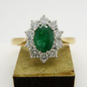 18ct yellow gold oval-cut emerald and round brilliant-cut diamond cluster ring.