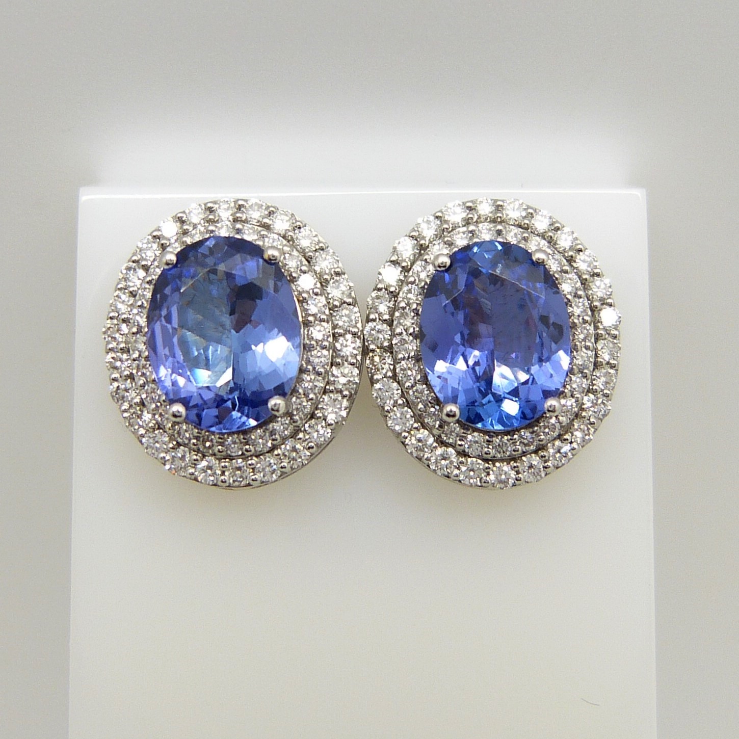 18ct white gold tanzanite and double diamond halo ear studs with screw backs, boxed.