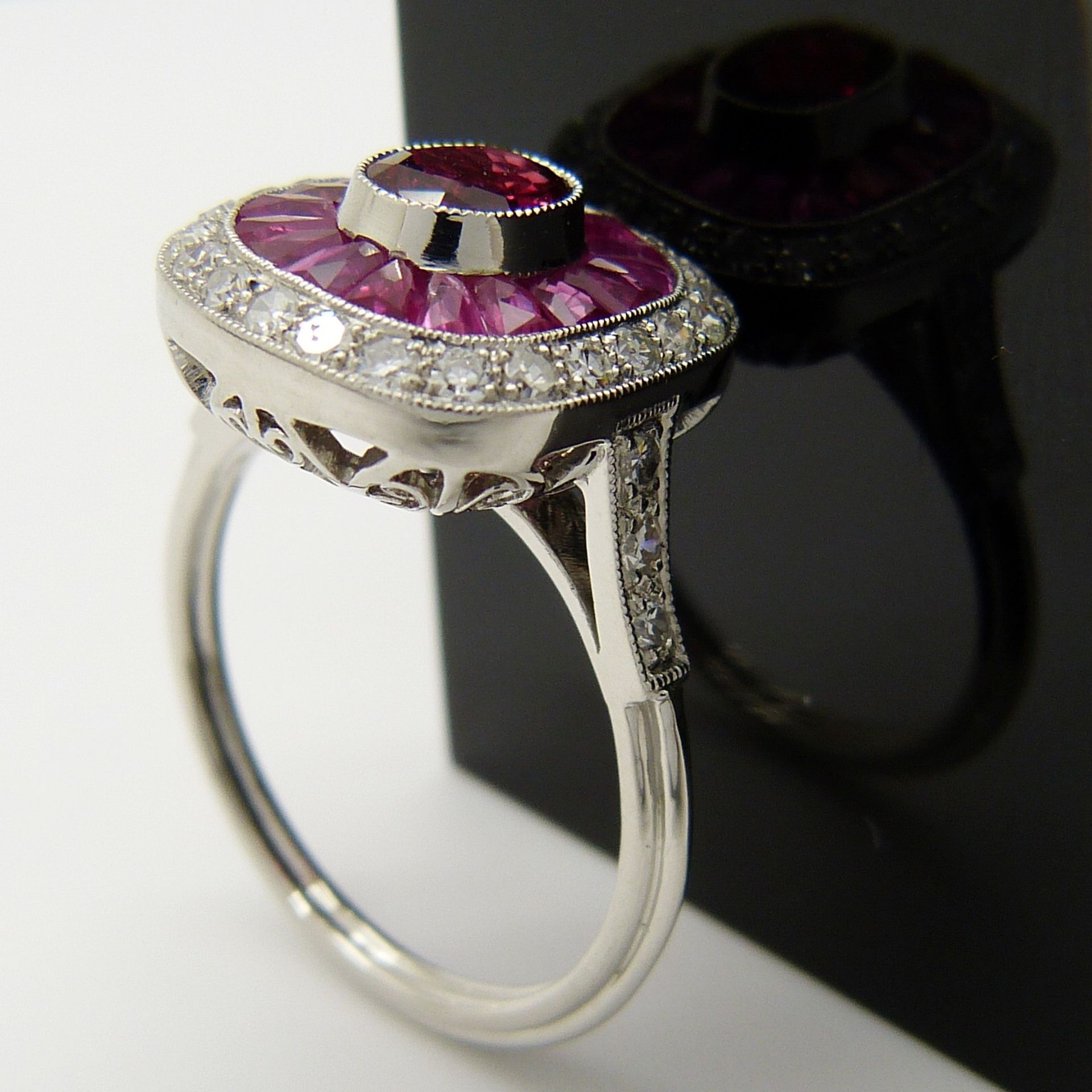A platinum ring set with central oval-cut and surrounding calibre-cut rubies and round brilliant-cut - Image 5 of 6