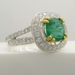 Stylish 14ct white gold emerald and diamond ring with diamond-set halo and shoulders