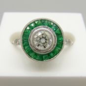 A target-style ring set with round brilliant-cut diamonds and emeralds, platinum