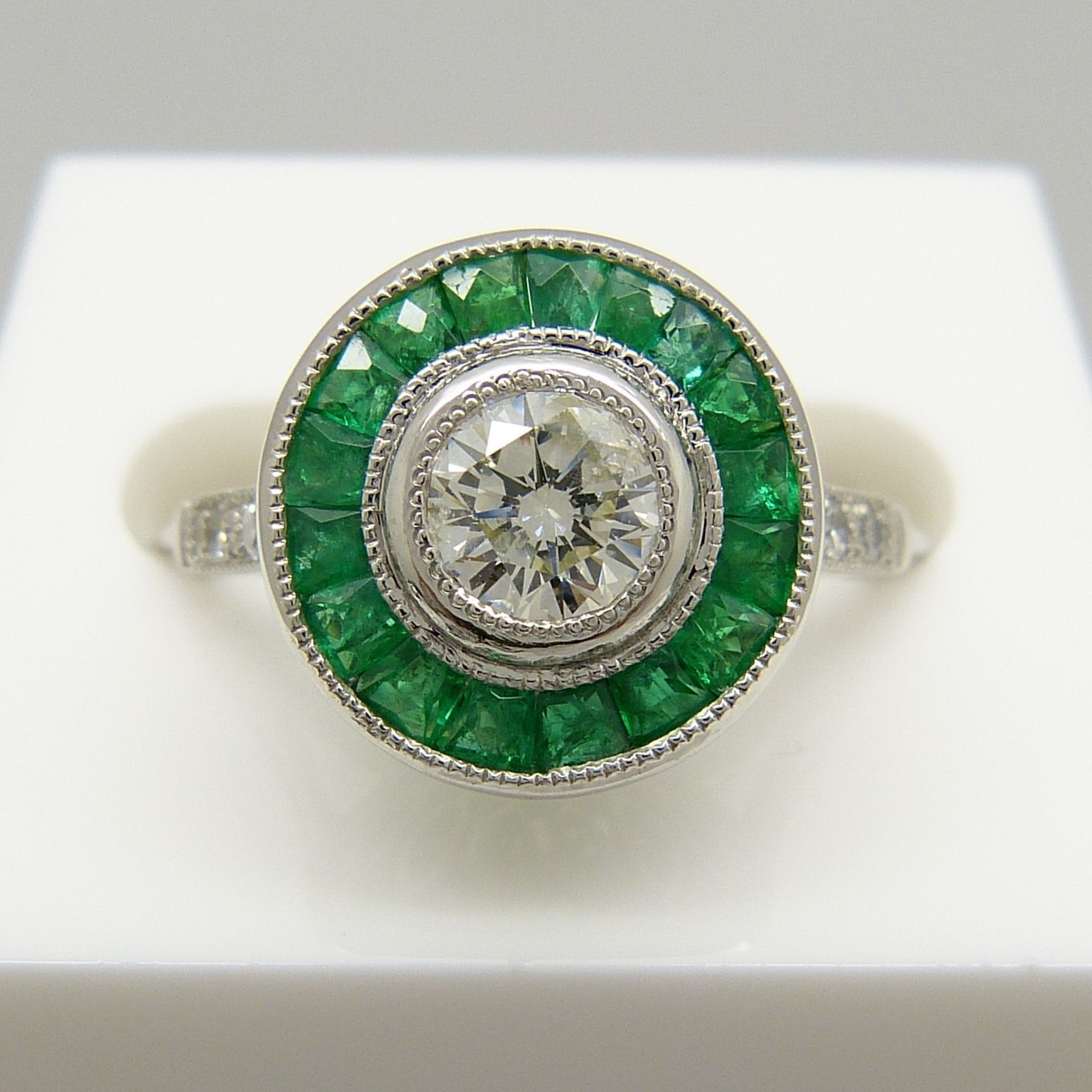 A target-style ring set with round brilliant-cut diamonds and emeralds, platinum