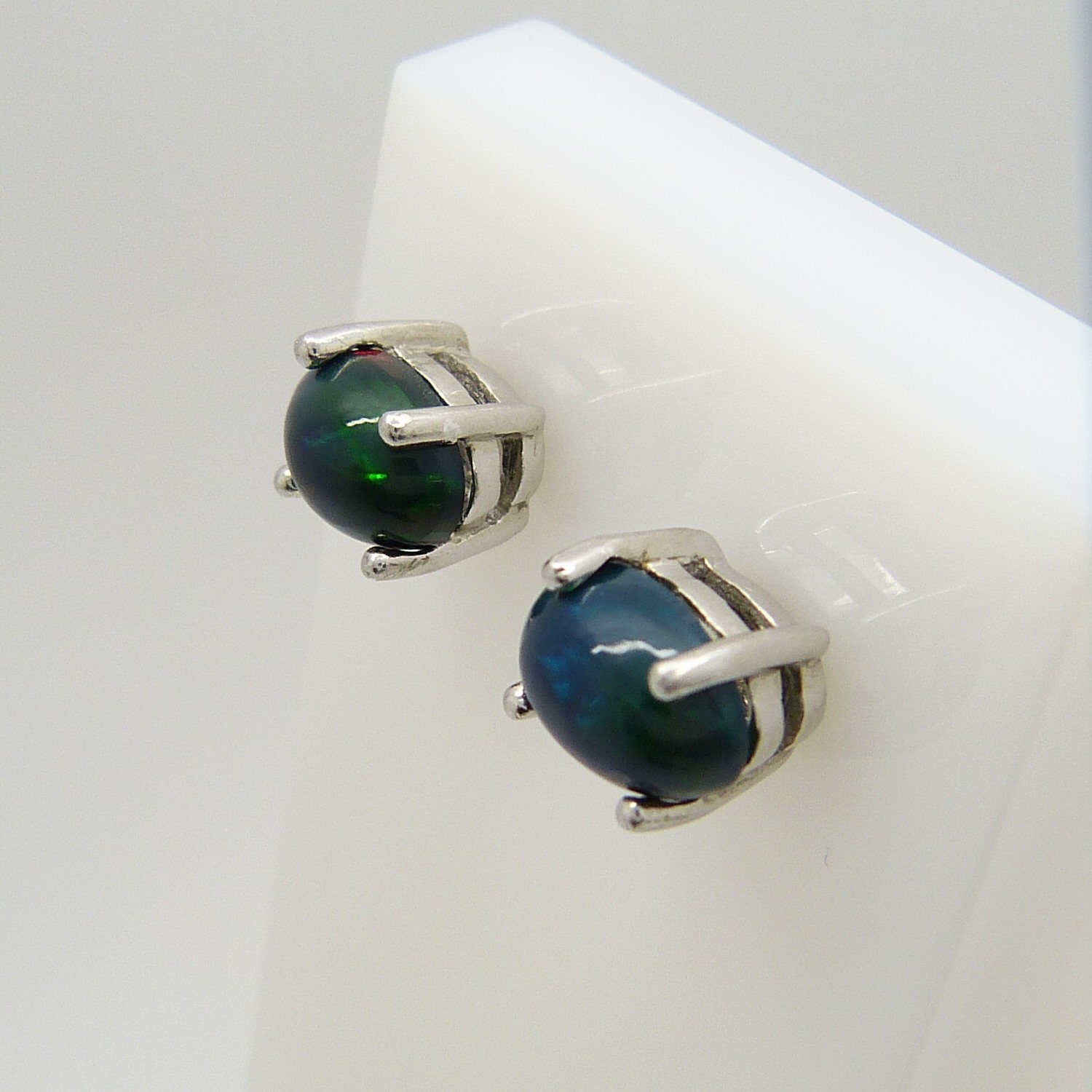 A pair of silver ear studs set with cabochon black Ethiopian opals, 1.10 carats (approx)