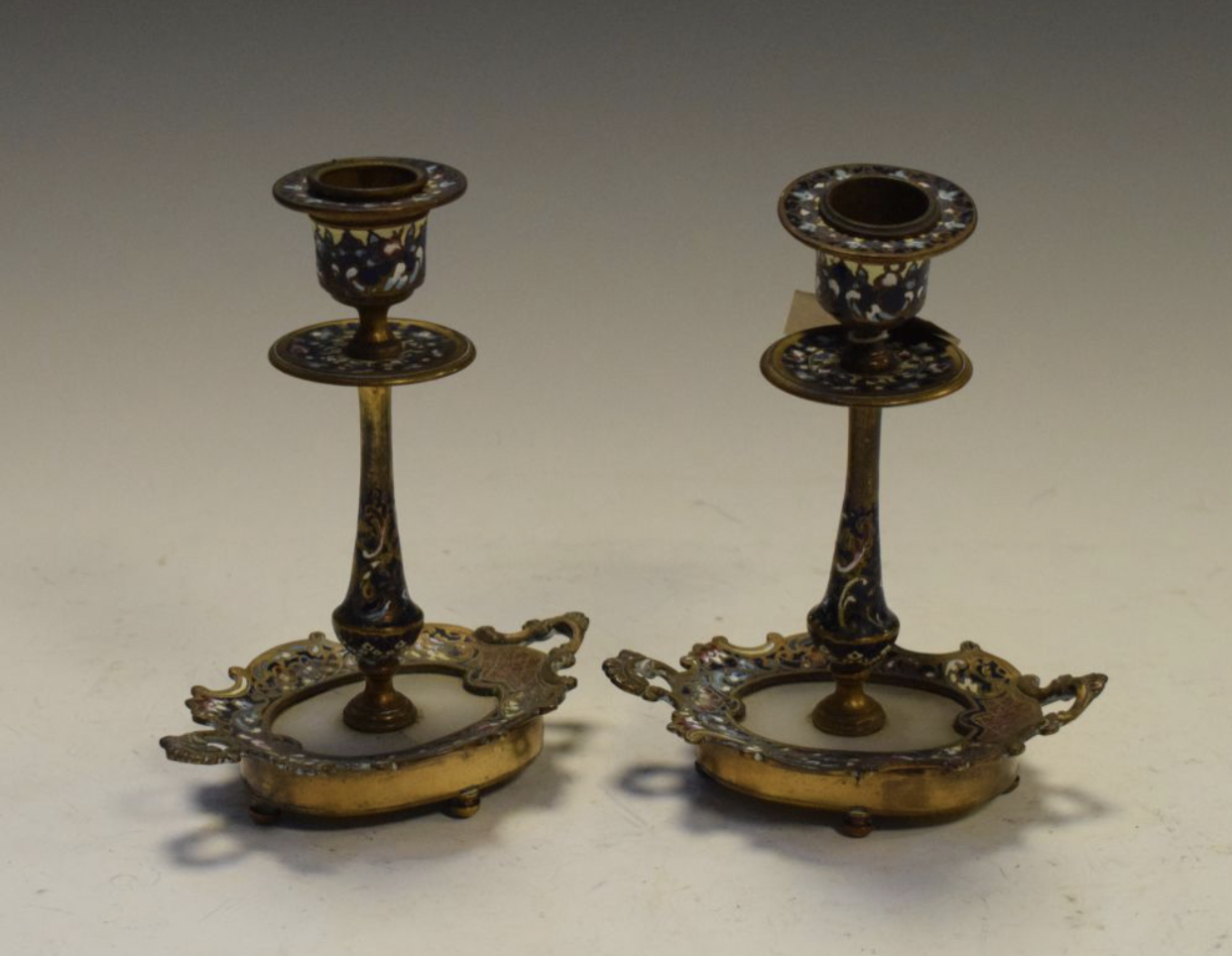 Pair of Continental gilt metal champlevé and alabaster candlesticks,