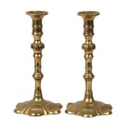 A pair of brass petal based candlesticks