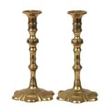 A pair of brass petal based candlesticks