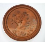 A terracotta roundel moulded with a ladies profile with ribbons in her hair,