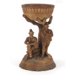 C19th Black Forest carved wooden bowl on figural stand depicting two peasants beneath a tree,