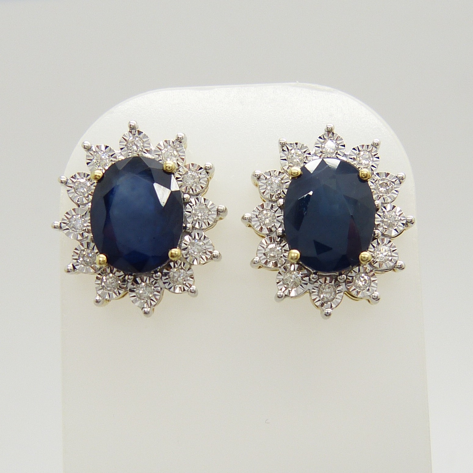 A stunning pair of 9ct yellow gold treated blue sapphire and diamond cluster ear studs, boxed.