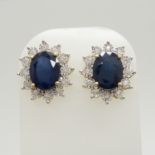 A stunning pair of 9ct yellow gold treated blue sapphire and diamond cluster ear studs, boxed.