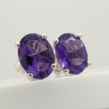 A pair of oval-cut 2.00 carat amethyst gemstone studs, in silver.