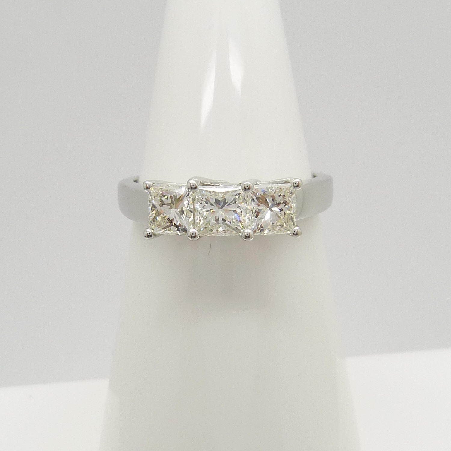 This is an 18ct white gold trilogy ring set with 1.00 carats of princess-cut diamonds.