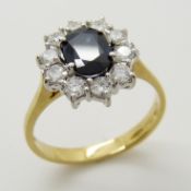 An attractive 18ct yellow and white gold oval-cut sapphire and diamond cluster ring.