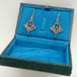 Pair of yellow gold and silver flared drop earrings set with blue sapphire gemstones and diamonds.