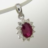An 18ct white gold oval-cut ruby and round brilliant-cut diamond pendant.