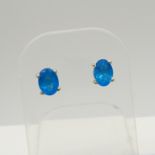 A pair of silver ear studs set with oval-cut neon blue apatites, 1.30 carats (approx).