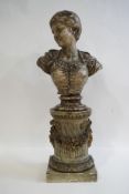 A 19th century Continental painted pottery bust of a woman on a socle and carved wooden column