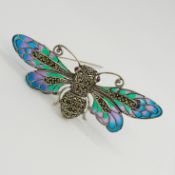 A large silver winged insect brooch set with cabochon rubies, marcasites and coloured enamel