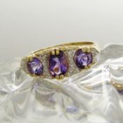 A Victorian-style dress ring set with amethysts and diamonds in 9ct yellow gold.