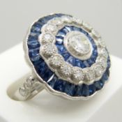 A large platinum floral-style diamond and sapphire cocktail ring.