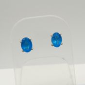 A pair of silver ear studs set with oval-cut neon blue apatites, 1.30 carats (approx).