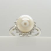 A classic-styled cultured pearl and diamond halo ring in 9ct white gold