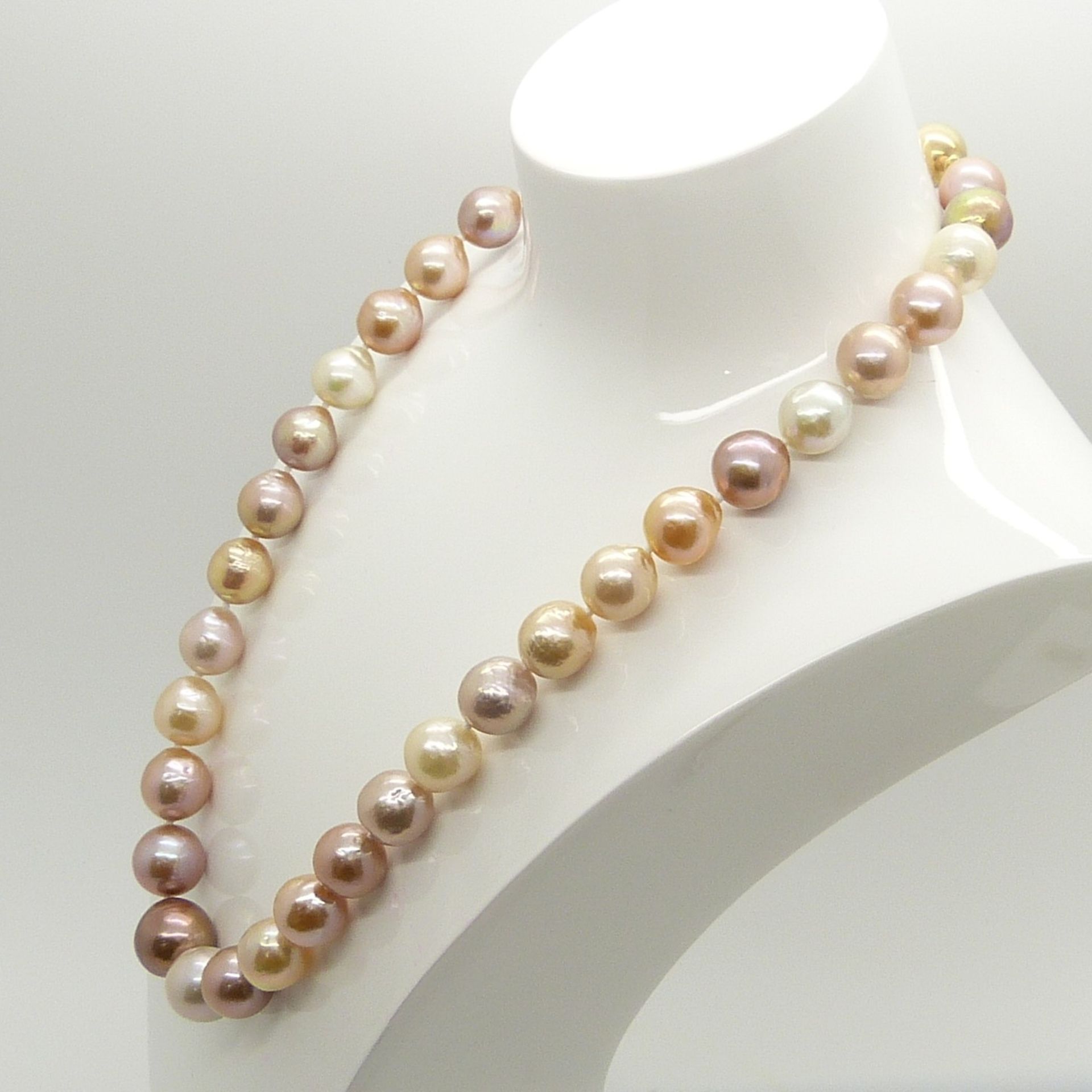A necklace strung with peach, white, champagne and grey freshwater pearls with 9ct yellow gold clasp