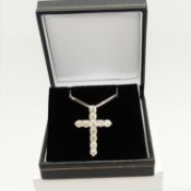 A 14ct white gold diamond cross pendant on a silver snake link chain, boxed