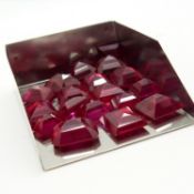 A parcel of 18 unmounted, unspecified red stones in various cuts, totalling 95.60 carats