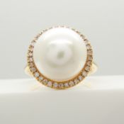 A classically styled 18ct rose gold ring set with a large cultured pearl and a halo of diamonds