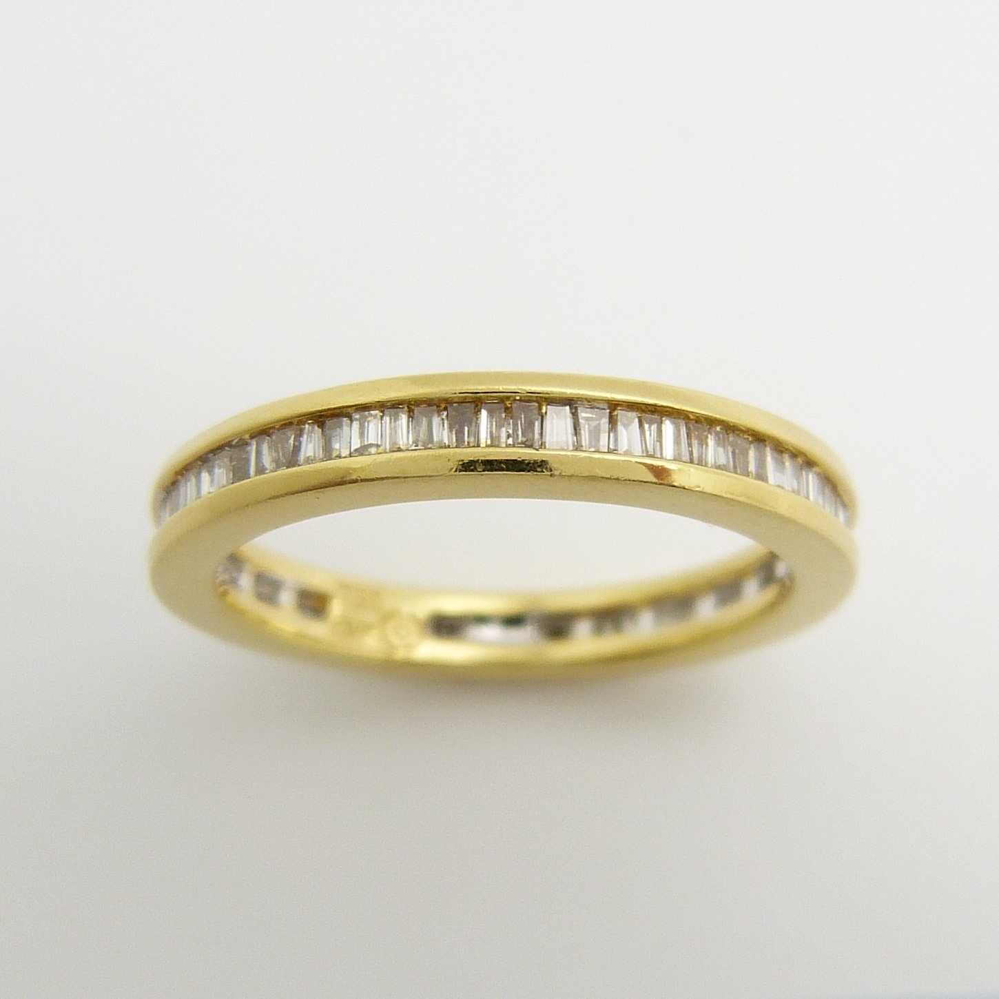 An 18ct yellow gold full eternity ring set with 0.50 carats of tapered baguette diamonds, certified