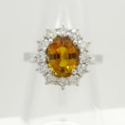A fine quality 1.64ct orange sapphire and 0.63ct diamond cluster ring is 18ct white gold