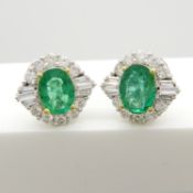 A certificated pair of 18ct gold oval-cut emerald and baguette & round brilliant-cut diamonds studs