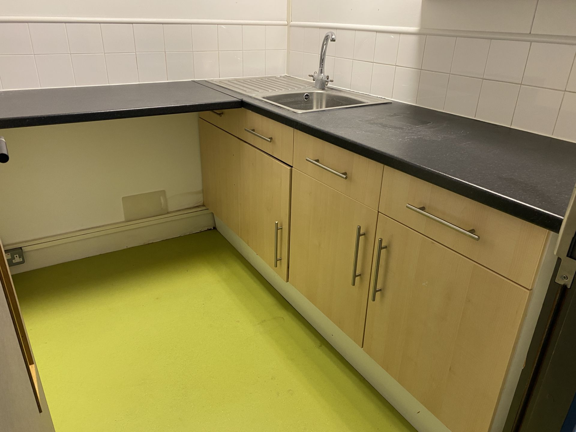 Small Kitchen area with cupboards, sink and tap.