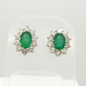 A pair of 18ct yellow and white gold emerald and diamond cluster studs, boxed