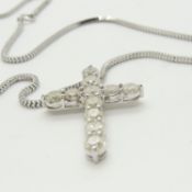 A 14ct white gold diamond cross pendant on a silver snake link chain, boxed