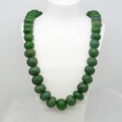 A large and weighty 890.00 ct earth-mined carved graduated emerald bead necklace with patterned cord