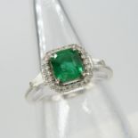 A square emerald ring with a diamond halo and tapered baguette diamond shoulders in 18ct white gold