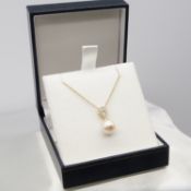 A classic cultured pearl and diamond bale necklace in 9ct yellow gold, boxed