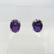 A pair of oval-cut amethyst-set ear studs in silver