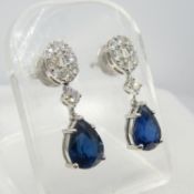 An exciting pair of pear shape sapphire and diamond cluster drop earrings in 18ct white gold