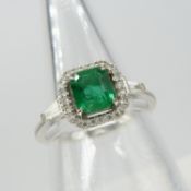 A square emerald ring with a diamond halo and tapered baguette diamond shoulders in 18ct white gold