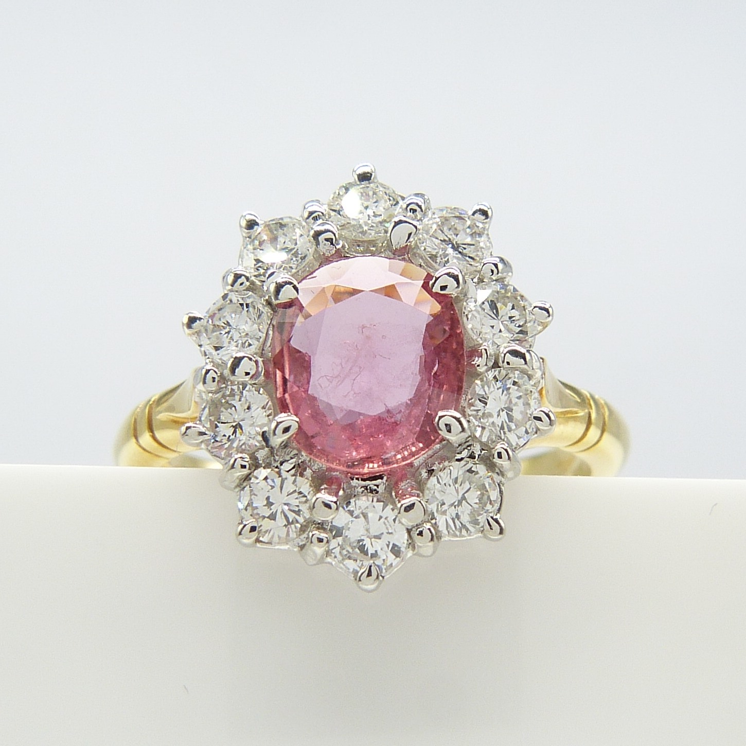 A pinkish-red natural Ruby and Diamond cluster ring in 18ct yellow and white Gold