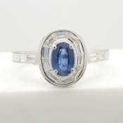 An exquisite 18ct white gold oval blue sapphire ring with trapezoid and baguette diamonds