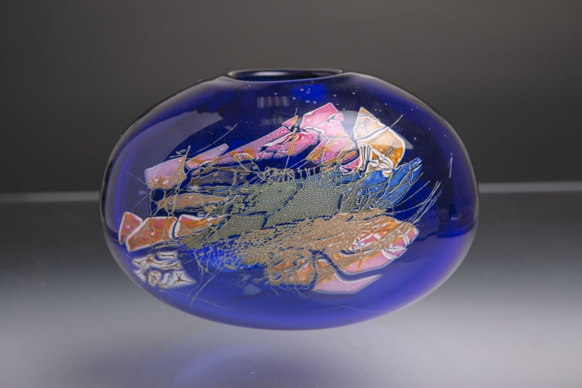 Glasstudiovase (1994), blaues Glas m. abstrakter Darstellung, bauchige seitlich abgeflachte Form,