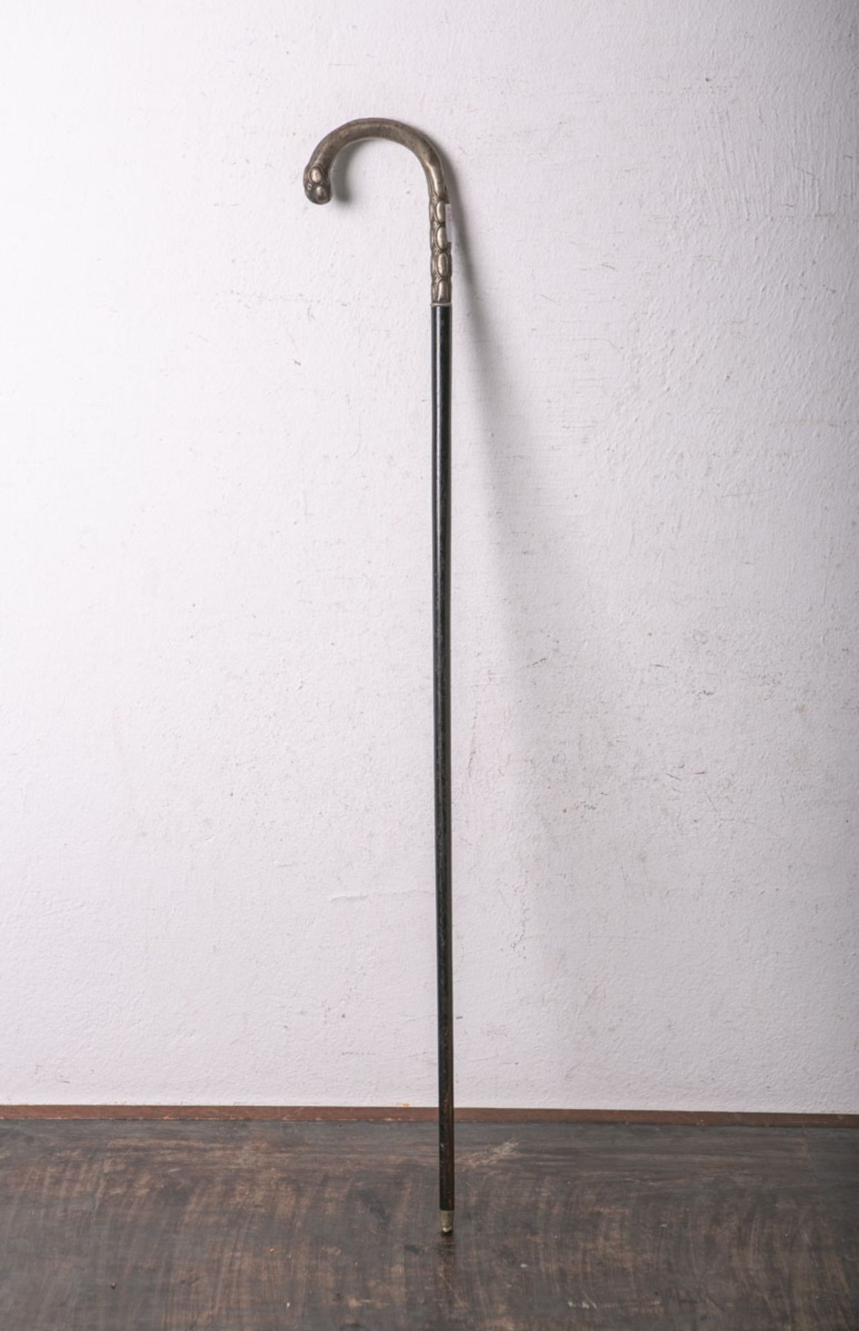 Gehstock, Knauf aus Metall m. stilisiertem Nuppendekor, ebonisiertes Holz, L. ca. 87 cm.