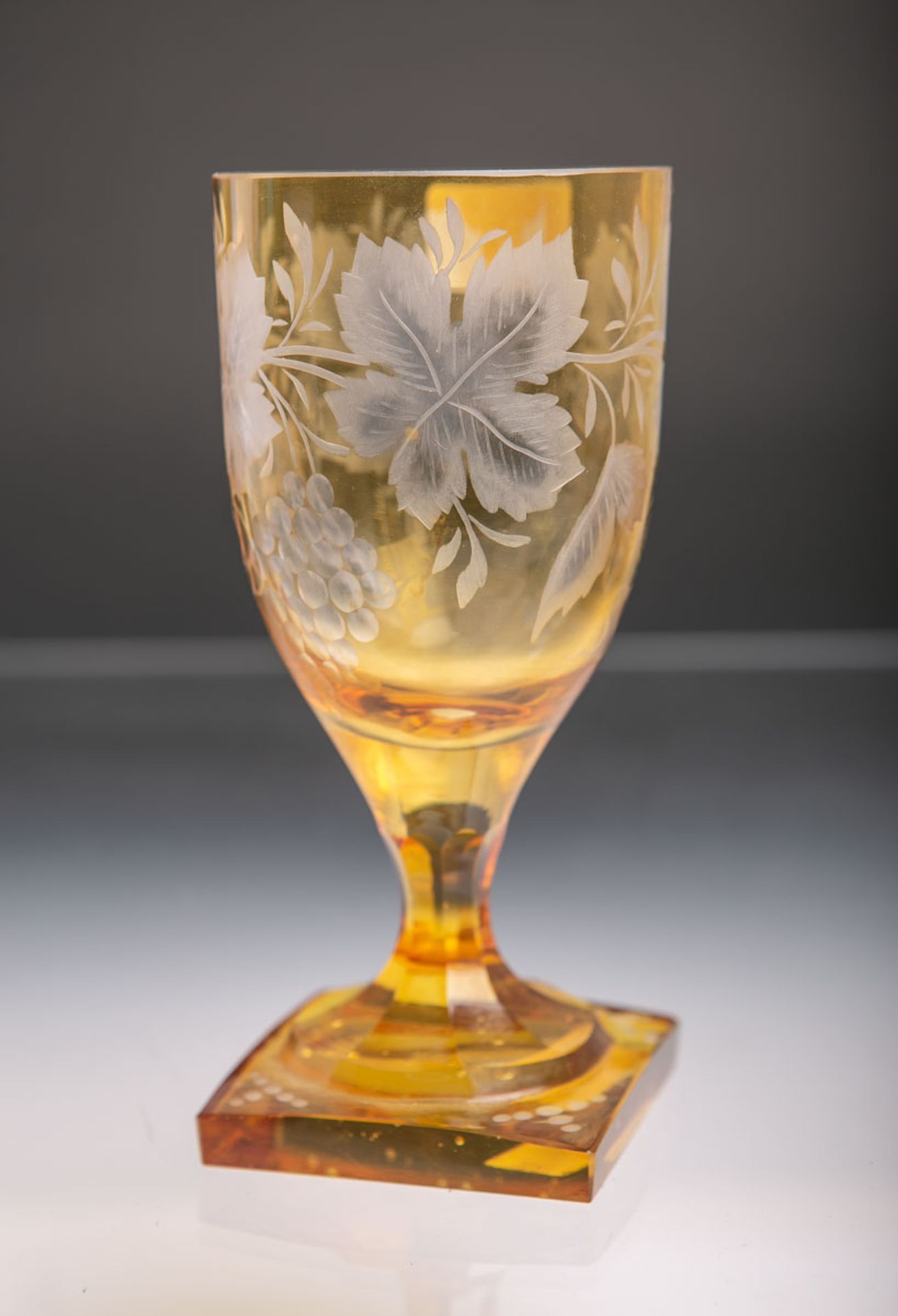 Pokalglas (wohl 20. Jh.), dickwandiges klares Glas gelb überfangen u. geschliffen, auf quadratischem
