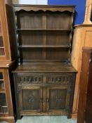 A dark oak dresser with plate rack above and cupboard below (H174cm W91cm D43cm)